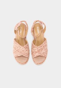 Sandales tissées roses avec un design à lanières croisées, sangle de cheville réglable et semelle plate. Finition texturée et semelle intérieure légèrement rembourrée.