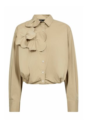 Beige cropped paita, jossa vasemmalla puolella suuri, teksturoitu kukka koristeena, klassisella kauluksella ja napitettavalla edessä.