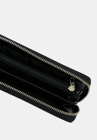 Portafoglio nero con zip, con una texture esterna, hardware color oro e molteplici scomparti, dotato di una fodera interna liscia.