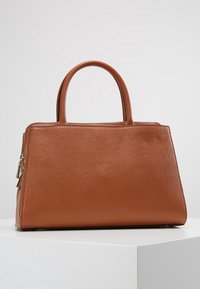 Sac à main en cuir marron avec un design structuré, deux poignées supérieures et une texture lisse, doté d'une fermeture éclair et de détails de couture subtils.