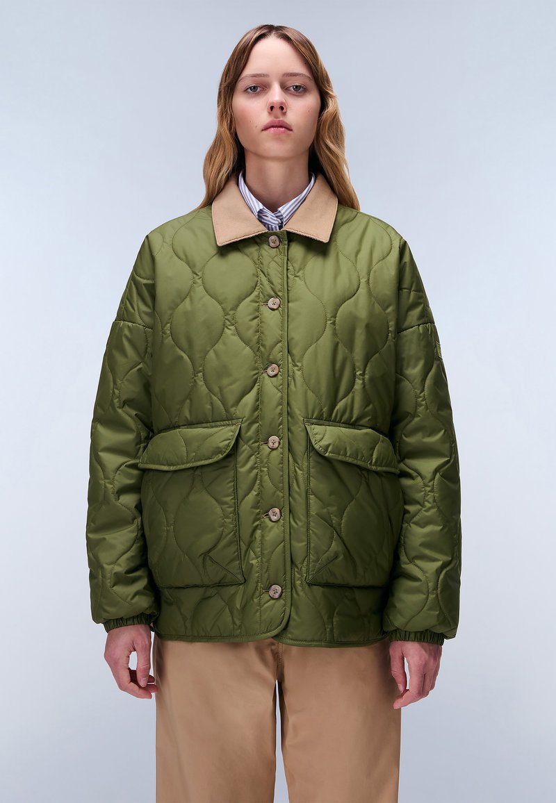 Giacca trapuntata verde con colletto beige, dotata di due tasche frontali e chiusure con bottoni. Materiale liscio con una consistenza morbida.