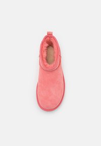 Bottine en daim rose avec une doublure intérieure douce et moelleuse, un bout arrondi et un profil bas. Dotée d'un col piqué et d'une languette à l'arrière.