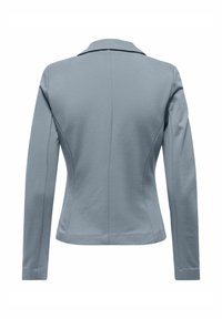 Blazer ajusté bleu clair à manches longues, coutures cintrées et col étroit, vu de dos sur un fond blanc.