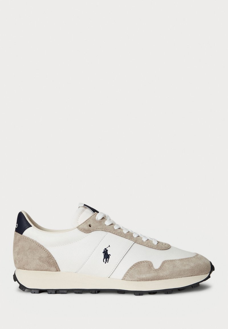 Valge ja beež sametist sneaker musta kummist tallaga ning Polo logo külgedel, vaadatuna väljastpoolt valge tausta ees.