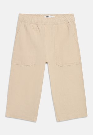 Παντελόνια παιδικά φαρδιά σε μπεζ χρώμα με ελαστική μέση και εμπρός τσέπες με επιπλέον ύφασμα, κατασκευασμένα από ελαφρύ ύφασμα.