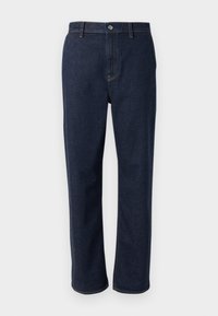 Temno modri jeans s ravnim krojem, opremljeni z zadrgo, sprednjimi žepi in vidnimi šivi v kontrastni barvi.