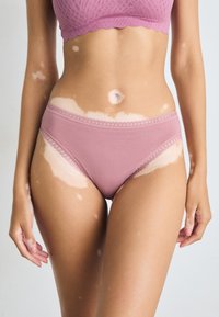 Light pink cotton underwear with lace trim at the waistband and leg openings. Smooth texture with a modest cut, designed for comfort.