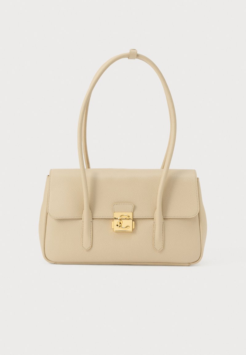 Beige leren handtas met lange bandjes en een vergulde vierkante sluiting aan de voorkant, weergegeven tegen een witte achtergrond.