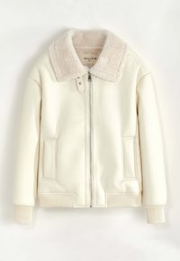 Veste en faux cuir crème avec un col en fourrure beige clair, fermeture éclair à l'avant et poignets côtelés. Comprend deux poches latérales. Design simple.