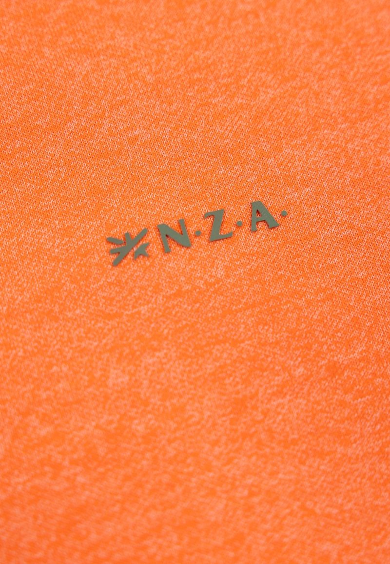 Pomarańczowy materiał o teksturowanej powierzchni z srebrnym logo N.Z.A. na dole. Projekt jest prosty, bez dodatkowych wzorów ani akcentów.
