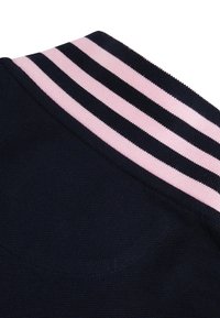 Gros plan d'un tissu bleu marine foncé avec un col à côtes comportant deux rayures horizontales roses et deux noires.