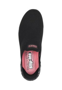 Zapato negro sin cordones con parte superior de punto texturizado, plantilla de espuma viscoelástica rosa, y una etiqueta que muestra "SKECHERS" y "Slip-ins" en blanco y rojo.