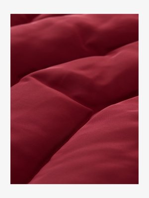 Bordeauxrode gewatteerde dekbed met een gladde textuur, voorzien van parallelle stiklijnen en een zacht, weelderig ontwerp.