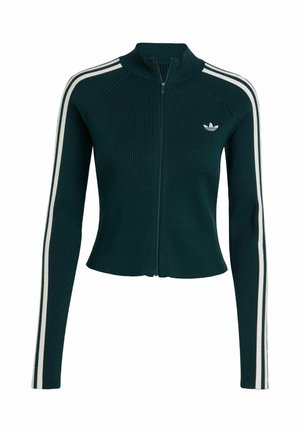 Veste zippée verte à côtes avec un col haut, présentant des bandes blanches sur les côtés et un petit logo blanc sur la poitrine. Design ajusté.