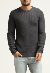 Donkergrijze geribbelde breisweater met een ronde hals, lange mouwen en een aansluitende tailleband. Gemaakt van een gestructureerde stof.
