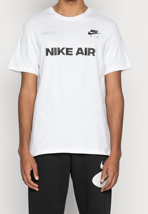T-shirt en coton blanc à manches courtes, avec l'inscription "NIKE AIR" en noir en caractères gras et un petit logo noir sur la poitrine.