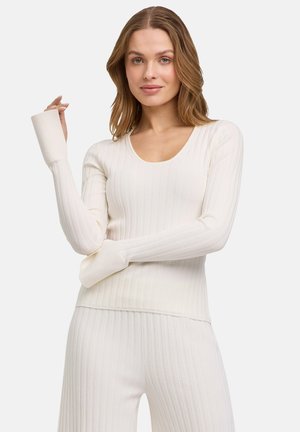 Top bianco a maniche lunghe a coste con scollo rotondo e polsini con apertura per il pollice, realizzato in un tessuto elasticizzato e testurizzato.
