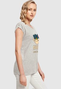 Grijze T-shirt met korte mouwen van zachte stof, met een cartoonafbeelding op de voorkant en de tekst "NOPE not today" eronder.