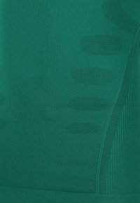 Grön sporttyg med texturerade mönster, inkluderande ovala och randiga designer, med en slät finish och medelhög stretch.