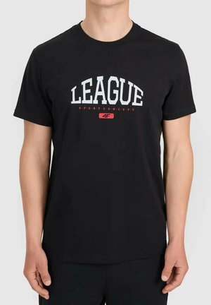 Mężczyzna noszący czarną koszulkę z krótkim rękawem z białym napisem "LEAGUE" i mniejszym czerwonym napisem "SPORT CONCEPT" nad czerwonym logo na piersi.