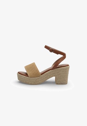Beige geweven sleehaksandaal met dikke hak, bruine enkelriem en gespsluiting.