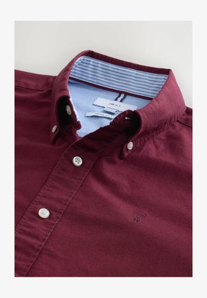 Camisa burdeos de botones con cuello clásico, que presenta un forro interior de rayas azul claro y botones blancos. Incluye un detalle bordado.