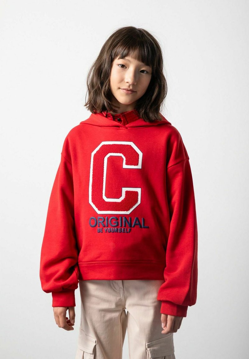 Czerwona bluza z kapturem z oversize'owym białym napisem "C" oraz niebieskim napisem "ORIGINAL". Materiał bawełniany, ściągacze przy mankietach i luźny krój.