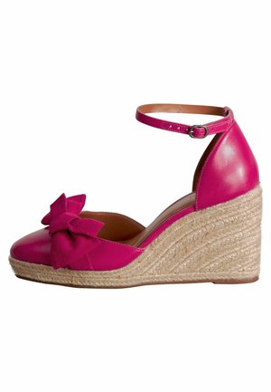 Fuchsia Leder Wedgeschuh mit einer strukturierten Jute-Plattform, ausgestattet mit einer dekorativen Schleife aus Wildleder am Vorderfuß und einem verstellbaren Knöchelriemen.