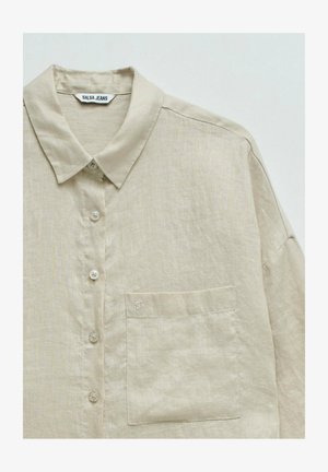 Chemise beige en lin à manches longues avec col, boutons sur le devant, poche poitrine et étiquette "SALSA JEANS" à l'intérieur du col.