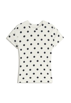 Biała koszulka z krótkim rękawem w czarne kropki równomiernie rozmieszczone na materiale, wyłożona płasko na białym tle.
