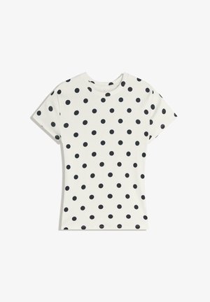Biele tričko s krátkym rukávom a čiernymi bodkami rovnomerne rozloženými po celej látke, zobrazené na bielom pozadí.