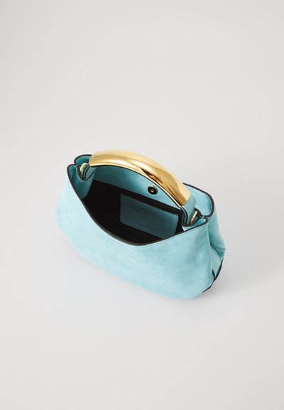 Turquoise suede handbag with a gold-tone curved handle, black interior, and inner pocket. Soft texture, rounded shape, minimalistic design.