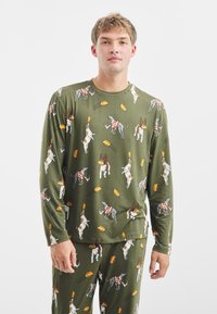 Zelený pyžamový set s hravým potiskem psů a fotbalů. Hladká tkanina, dlouhé rukávy a volný střih s kulatým výstřihem.