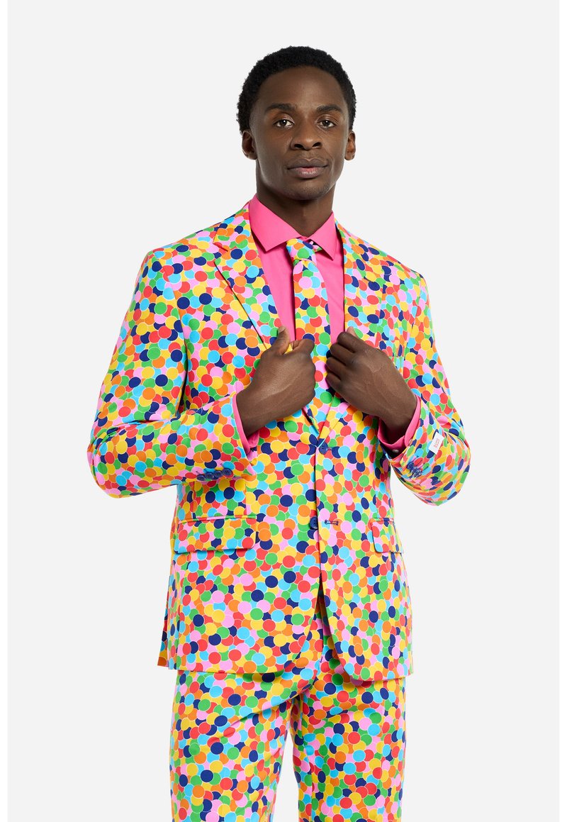 Completo a pois colorati con una base gialla decorata da pois rosa, blu, verdi e arancioni. Accompagnato da una camicia rosa e una cravatta coordinata.