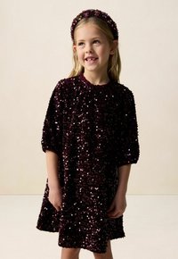 Bordeauxrotes Kleid, bedeckt mit Pailletten, kurze Ärmel, runder Ausschnitt und überknielange Länge; passendes Haarband mit Verzierungen.