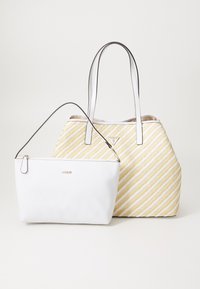 Sac en cuir blanc avec un logo doré, accompagné d'une petite trousse blanche. Le sac plus grand présente un motif rayé jaune et blanc.