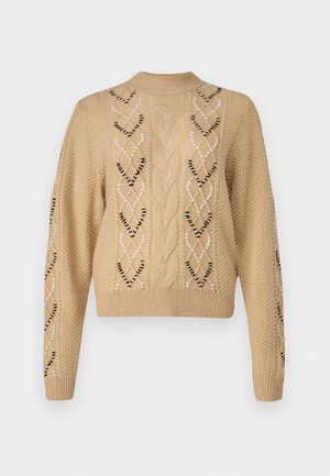 Beige knitted sweater with a cropped design, featuring cable knit and heart-shaped patterns along the sides and sleeves. Textured fabric.