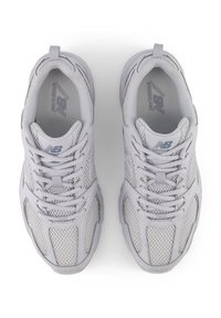 Scarpe da corsa grigio chiaro con tomaia in mesh, linguetta imbottita, chiusura con lacci e suola in gomma texturizzata. Logo sul lato.