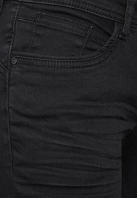 Svarta denimjeans med slim fit, som har en framficka och en subtil sömnadsstruktur. Slät yta med en lätt glans.