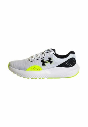 Zapatilla deportiva gris y blanca con acentos negros, parte superior de tela transpirable, logo y detalles en amarillo brillante, suela texturizada para tracción.
