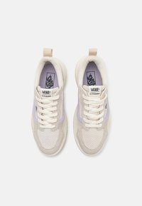 Beige Vans-sneakers med en teksturert semsket overdel, myke kremfargede aksenter og en lavendel sidepanel. Har hvite lisser og en pull-tab.