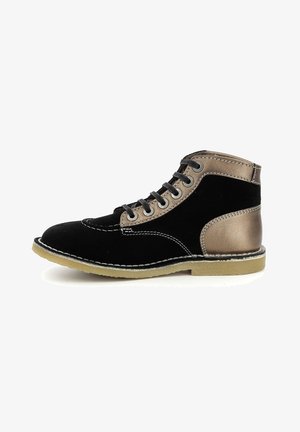 Botte montante noire et bronze avec lacets noirs, coutures contrastées et semelle en caoutchouc beige, vue de profil sur fond blanc.