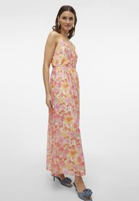Floral maxi dress with a soft, lightweight fabric featuring pink, orange, and yellow flowers. Spaghetti straps and an elastic waistband.