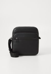 Borsa a tracolla in pelle nera con tasca frontale con zip, tracolla regolabile e logo impresso, caratterizzata da una texture liscia e un design semplice.