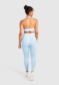 Top corto atletico blu chiaro e leggings a vita alta realizzati in tessuto elastico, caratterizzati da dettagli tagliati e design senza cuciture.