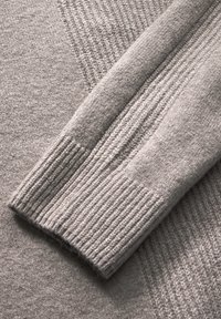 Grauer Pullover mit strukturiertem Strick, gerippten Bündchen und glatten Bereichen, der einen weichen Stoff mit unterschiedlichen Oberflächenmustern hervorhebt.