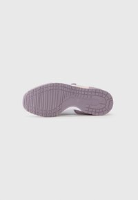 Semelle de chaussure en caoutchouc violet clair avec des motifs de grip texturés, design plat et forme légèrement incurvée. Accents en blanc et rose.