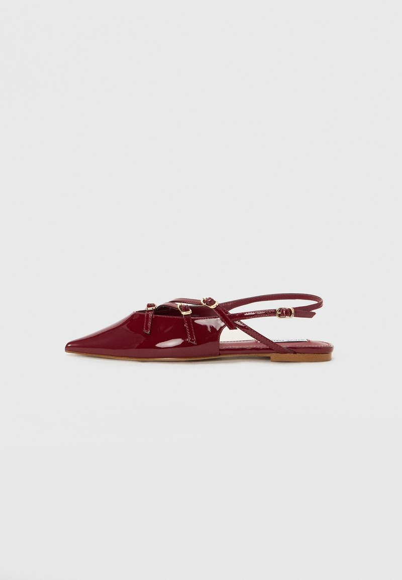 Chaussure slingback plate en cuir verni bordeaux avec bout pointu, trois brides à boucle sur le dessus et fine bride cheville avec boucle.