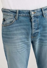 Vaqueros de denim azul claro con un diseño clásico de cinco bolsillos, que presentan un corte recto, un desvanecimiento sutil y un cierre de botón en la parte delantera.