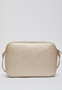 Obdélníková zlatá kožená crossbody taška s zaoblenými rohy a nastavitelným popruhem na jednobodovém světlém pozadí.
